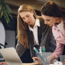 Two young women working together in office