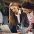 Two young women working together in office
